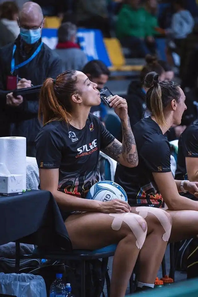 Female athlete drinking energy gel.